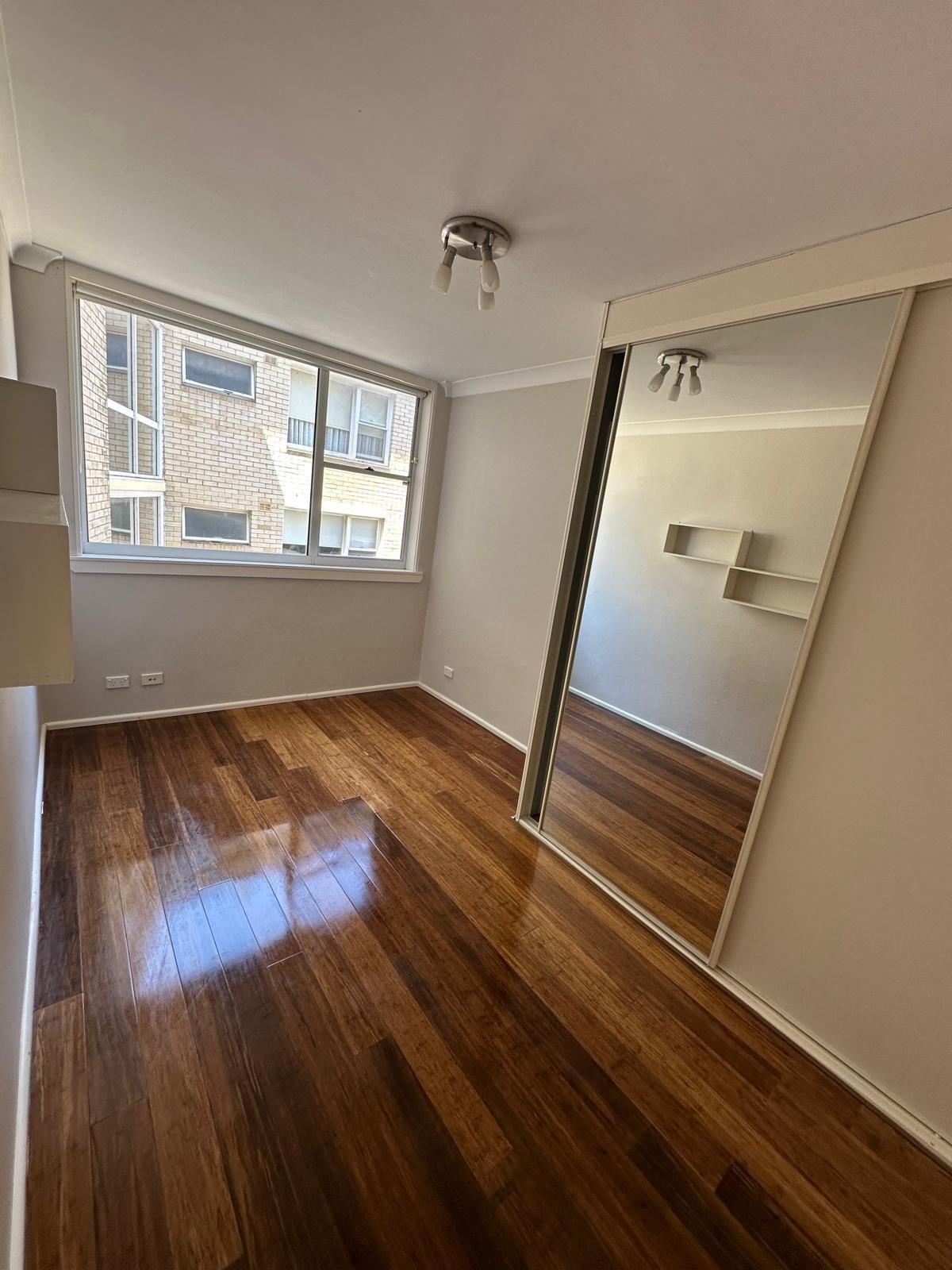 Clean empty bedroom with polished timber floors