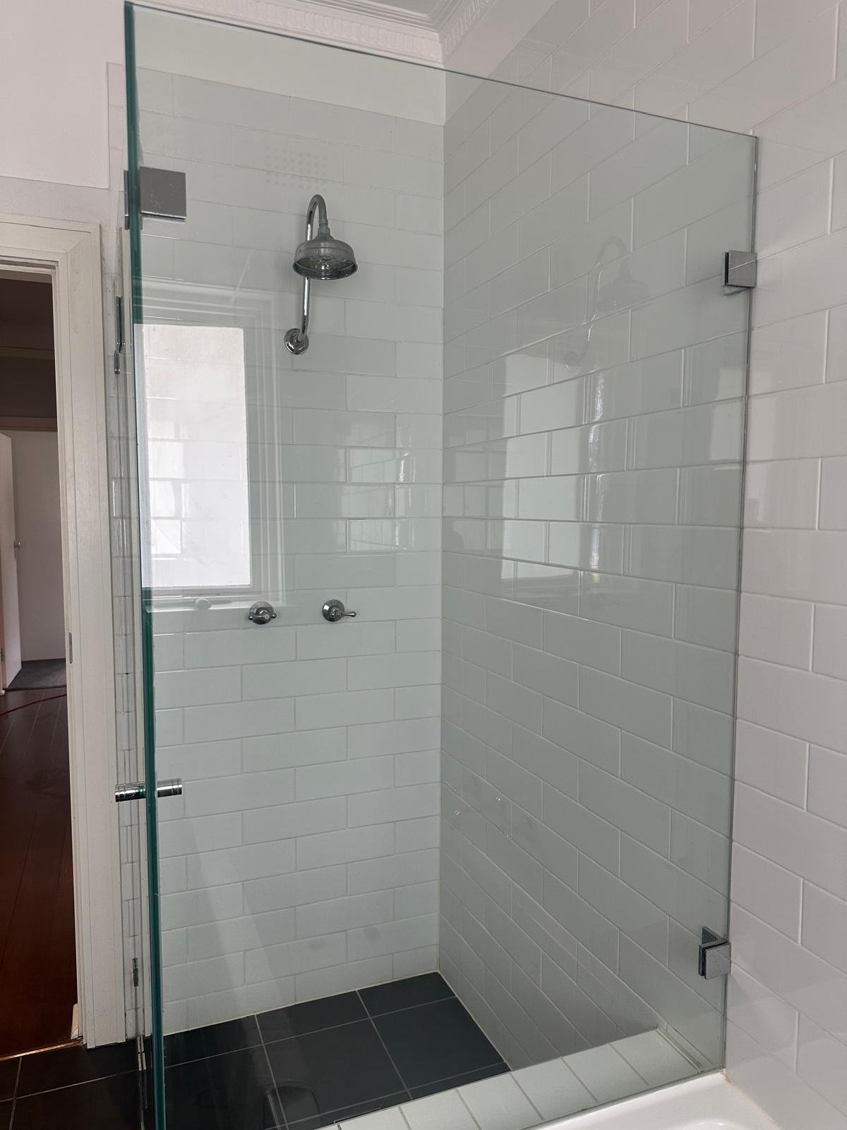 Sparkling glass shower with spotless tiles